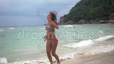 在多云的天气里，穿比基尼的年轻棕褐色漂亮女人在热带海滩海边奔跑。 慢动作。 <strong>1920</strong>x1080
